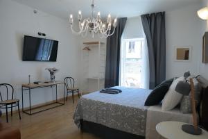 um quarto com uma cama e um lustre em SAVOIA & CAVOUR _ Premium Signature _ em Bari