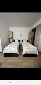 2 letti in una camera con lenzuola bianche di Gudauri Hotel Loft Apartment 323 a Gudauri