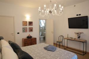 un soggiorno con divano e lampadario pendente di SAVOIA & CAVOUR _ Premium Signature _ a Bari