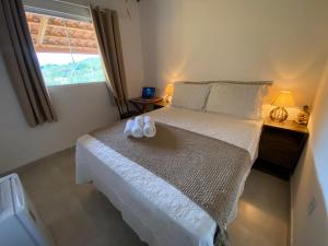 a bedroom with a bed with two towels on it at Chalé Capão Vibes in Vale do Capao