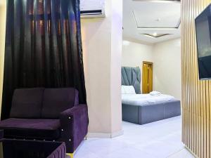 a living room with a couch and a bed at Clique Court Hotel & Suite in Opete