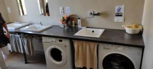 uma lavandaria com um lavatório e uma máquina de lavar roupa em La vita e bella em Saint-Jean-Pied-de-Port
