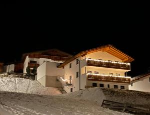 a building on top of a snowy hill with lights at Berghoamat Nauders in Nauders