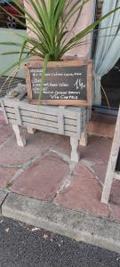 a wooden bench with a potted plant on a sidewalk at La vita e bella in Saint-Jean-Pied-de-Port