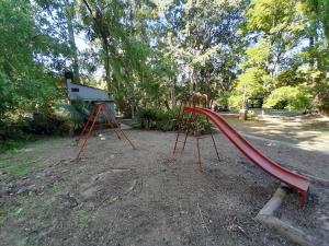 un parque infantil con un tobogán rojo en un parque en Casa en el delta con acceso terrestre en Belén de Escobar