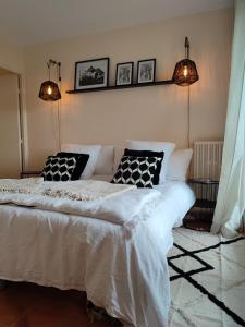 sypialnia z dużym białym łóżkiem z 2 poduszkami w obiekcie Le 3 appartement vue mer avec jardin 100m de la plage et de la thalasso w mieście Concarneau
