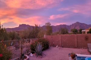 a backyard with a fence and mountains in the background at Honeysuckle Oasis in Gold Canyon