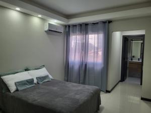 a bedroom with a large bed and a window at La Foret 2 dormitorios in Santa Cruz de la Sierra