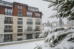 a snow covered apartment building in a city at President Kop Alex in Kopaonik