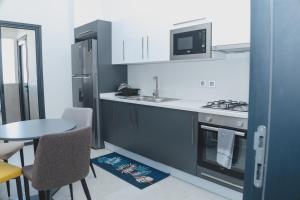 a kitchen with a table and a stove top oven at Appartment Luxe CAPUCINE dans la Zone B Dakar in Fass