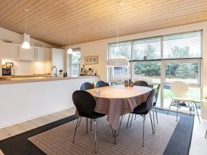 a kitchen and dining room with a table and chairs at 6 person holiday home in L kken in Løkken