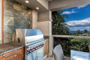 an outdoor kitchen with a stove and a balcony at Ho'olei Ocean View by Coldwell Banker Island Vacations in Wailea