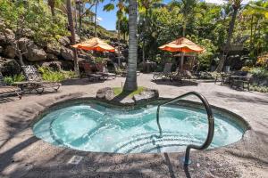 a small swimming pool with an umbrella and tables and chairs at Ho'olei Ocean View by Coldwell Banker Island Vacations in Wailea