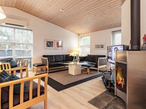 a living room with a couch and a tv at 6 person holiday home in L kken in Løkken