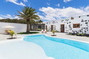 una villa con piscina frente a una casa en Eco Living Olivos76, en Tías