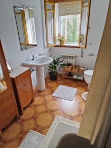 a bathroom with a sink and a toilet and a tub at Exclusiva Casa Rural Mariano con acceso directo al rio in Baralla