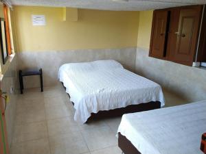 ein Schlafzimmer mit 2 Betten und einem Stuhl darin in der Unterkunft Finca La Gaviota in Montenegro