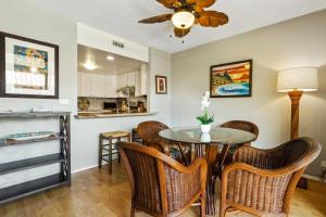 - une cuisine et une salle à manger avec une table et des chaises dans l'établissement Big Island White Sands Village by Coldwell Banker Island Vacations, à Kailua-Kona