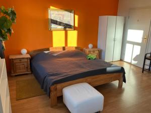 a bedroom with a bed with an orange wall at Altes Stadtgut am Bauhaus Museum in Weimar