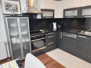 a kitchen with black cabinets and a stainless steel refrigerator at Apartman Jasmina in Bihać