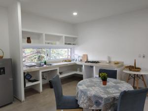 uma cozinha com uma secretária, uma mesa e cadeiras em Casa Mango amplia con alberca y cerca de la Media Luna !!! em Río Verde