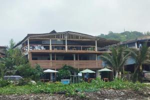 a large building with tables and umbrellas in front of it at Room Papagayo - Ayampe in Ayampe