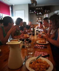 a group of people sitting at a table eating food at La vita e bella in Saint-Jean-Pied-de-Port