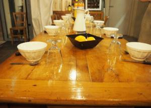 a wooden table with bowls and wine glasses on it at La vita e bella in Saint-Jean-Pied-de-Port