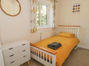 Dormitorio pequeño con cama y espejo en 6 Hunters Green Close, en Chinley