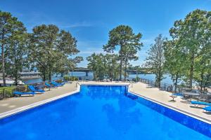 a large swimming pool with blue chairs and trees at Quaint Condo with Views and Pool Access! in Hot Springs