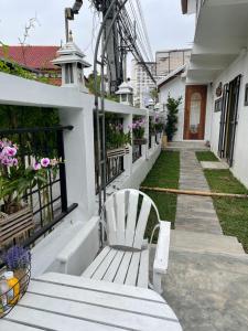 a white bench sitting on the side of a building at Mesa Garden Villa in Chiang Mai