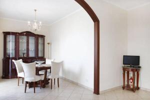 a dining room with a table and white chairs at Appartamento Vacanze Catania in Catania