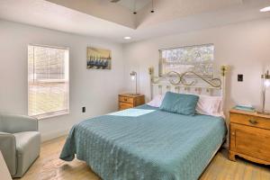 a bedroom with a bed and a chair and two windows at Pet-Friendly Cocoa Home with Covered Porch! in Cocoa