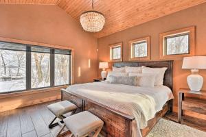 een slaapkamer met een groot bed en 2 ramen bij Lakefront Cabin Retreat, 2-Acre Lot with Deck! 