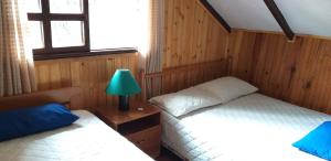 1 Schlafzimmer mit 2 Betten, einer Lampe und einem Fenster in der Unterkunft Bosque de Niebla Birding & Nature in Cali