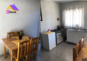une cuisine et une salle à manger avec une table et une cuisine avec un évier dans l'établissement Apartamento Loft encantador com patio, à Foz do Iguaçu