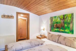 1 dormitorio con 1 cama con una pintura de ciervo en la pared en Ferienwohnung Gamsbock Panorama View Balkon, Gartensauna, Garten, Grillplatz en Stumm