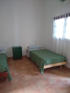 1 dormitorio con 2 camas en una habitación con ventana en Residencial ANAHATA en Capilla del Monte