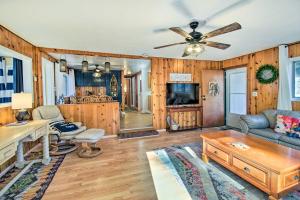 a living room with wooden walls and a ceiling fan at Near Fool Hollow Lake and Trails Family Cabin in Show Low