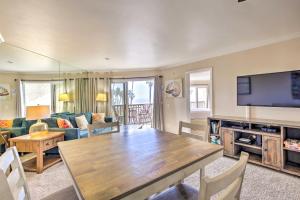 a living room with a table and a television at Oceanfront Condo, Walk to Pacific Beach! in San Diego