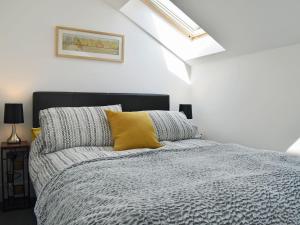 利德尼的住宿－Perivale Lodge，一间卧室配有一张黄色枕头的床