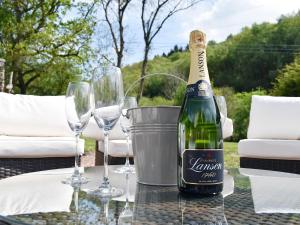 a bottle of champagne sitting on a table with wine glasses at Perivale Lodge in Lydney
