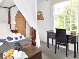 a bedroom with a bed and a desk with a desk at Coppice Hill House in Bishops Waltham