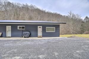 a small blue building with a parking lot at Mullens Cabin with Gas Grill and Mountain Views! in Mullens