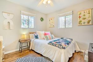 a bedroom with a bed and a nightstand and two windows at Asheville Area Bungalow Near Biltmore Estate in Arden