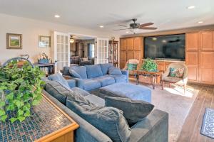 a living room with blue couches and a tv at Port Charlotte Home Heated Pool and Chefs Kitchen! in Port Charlotte