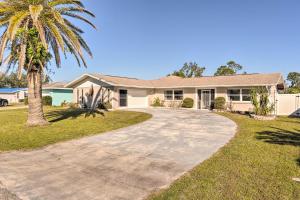 a house with a palm tree and a driveway at Port Charlotte Home Heated Pool and Chefs Kitchen! in Port Charlotte