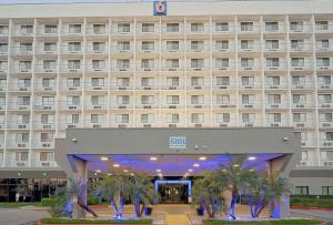 a large building with palm trees in front of it at Motel 6-Los Angeles, CA - Los Angeles - LAX in Inglewood