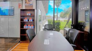 einen Konferenzraum mit einem Tisch, Stühlen und einem Fenster in der Unterkunft Motel 6-Los Angeles, CA - Los Angeles - LAX in Inglewood