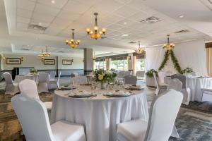 a banquet room with white tables and chairs and chandeliers at Best Western Plus Chocolate Lake Hotel - Halifax in Halifax